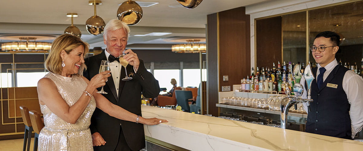 A couple enjoying drinks in the Britannia Lounge on Spirit of Discovery